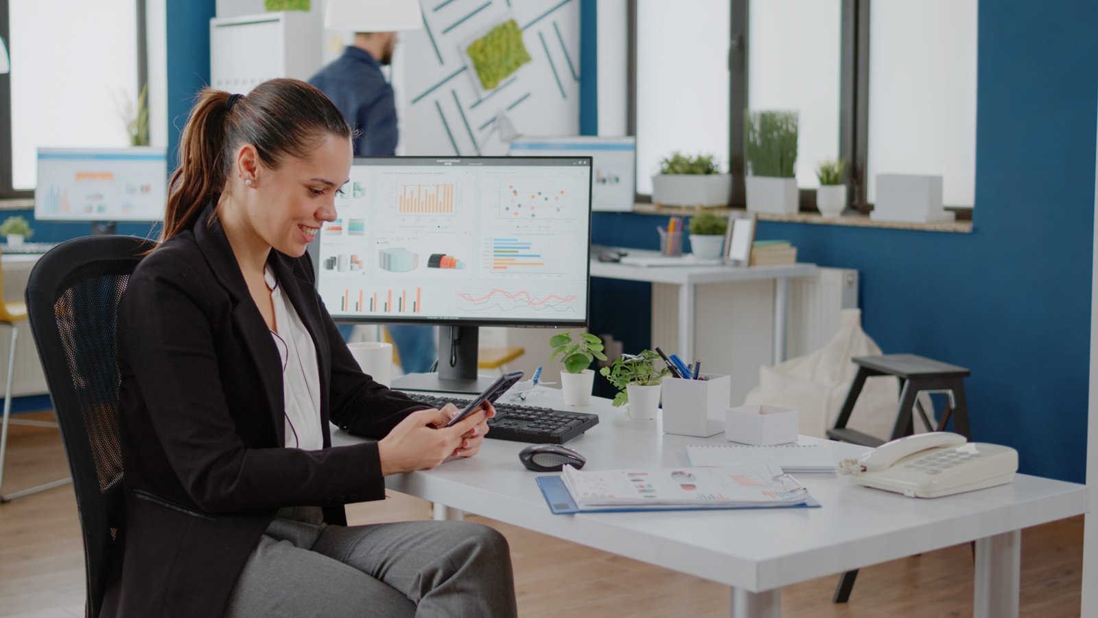 agent working at a desk with a laptop, phone, and CRM dashboard,